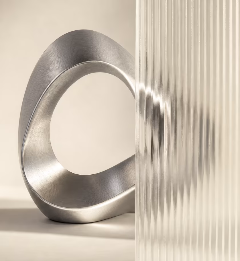 Polished steel loop in front of a ribbed glass panel