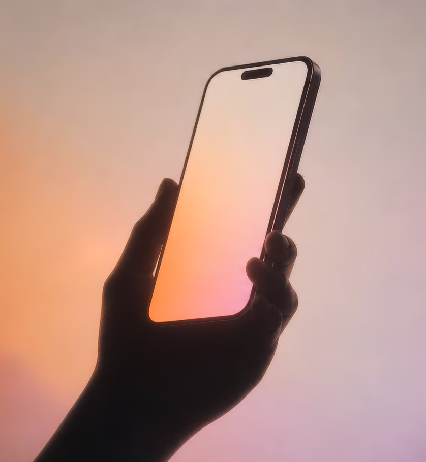 Hand holding a phone with a warm gradient screen