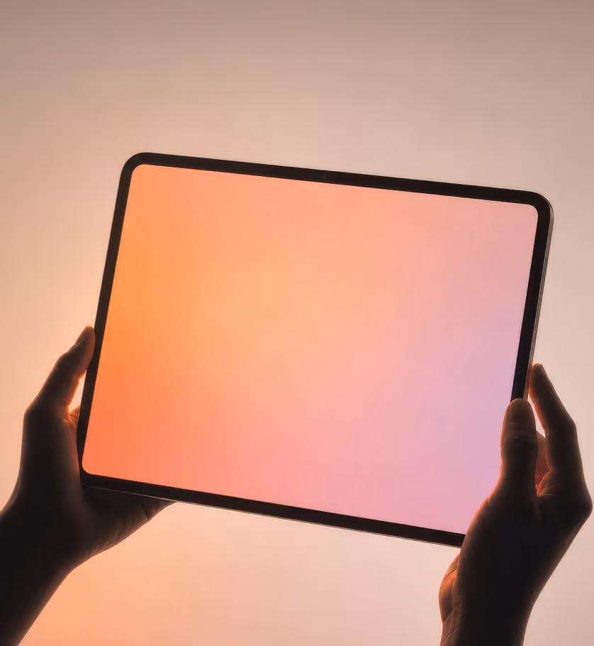 Hands holding a tablet with a warm gradient screen