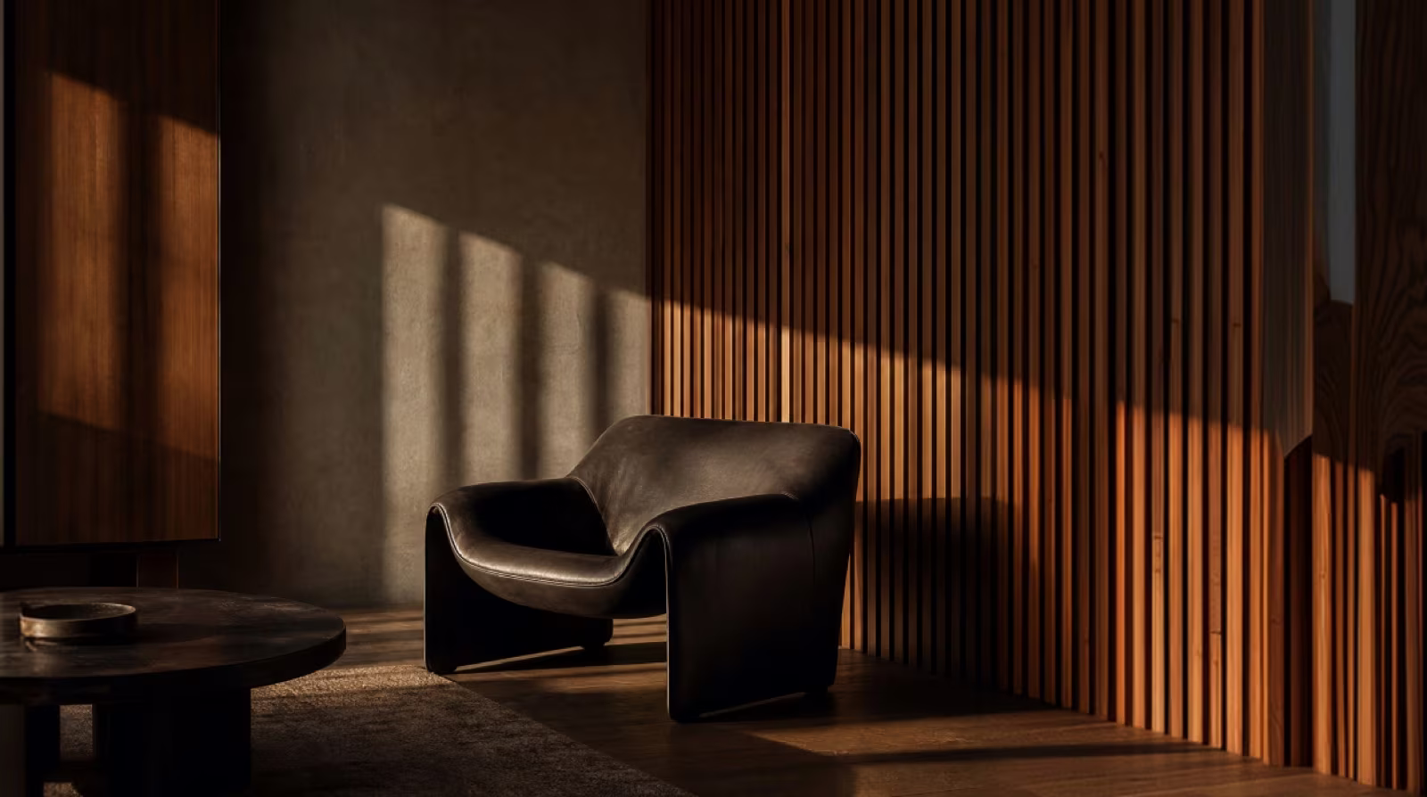 Dark lounge chair in a room with wooden slats and warm light